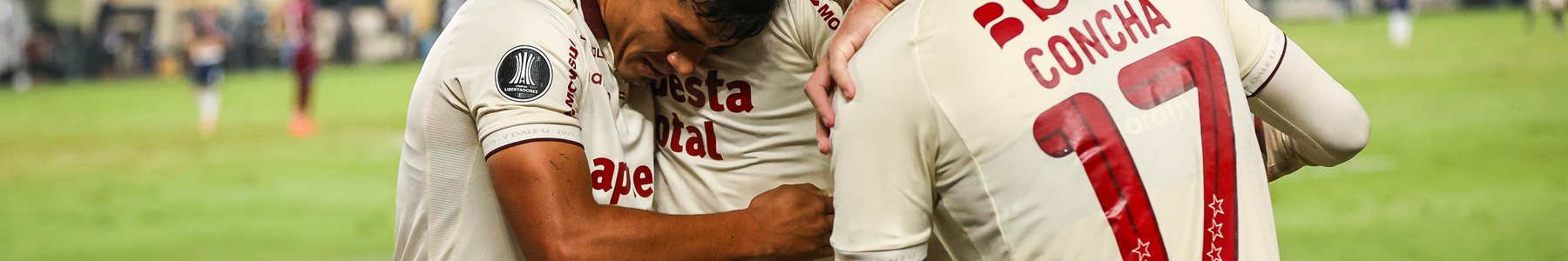 Jugadores de Universitario celebrando con la camiseta crema y el dorsal Concha 17